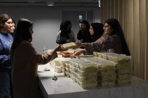 Volunteers hand out meals including chicken biryani, butter chicken and vegetarian lasagna