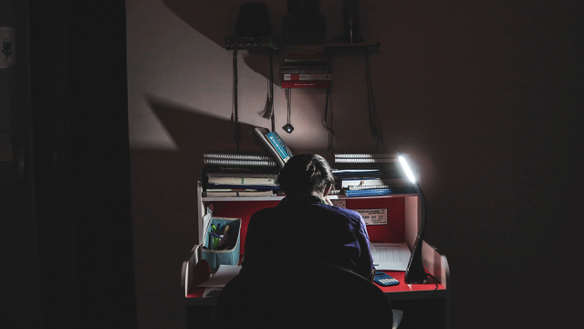 person studying at their desk in the dark
