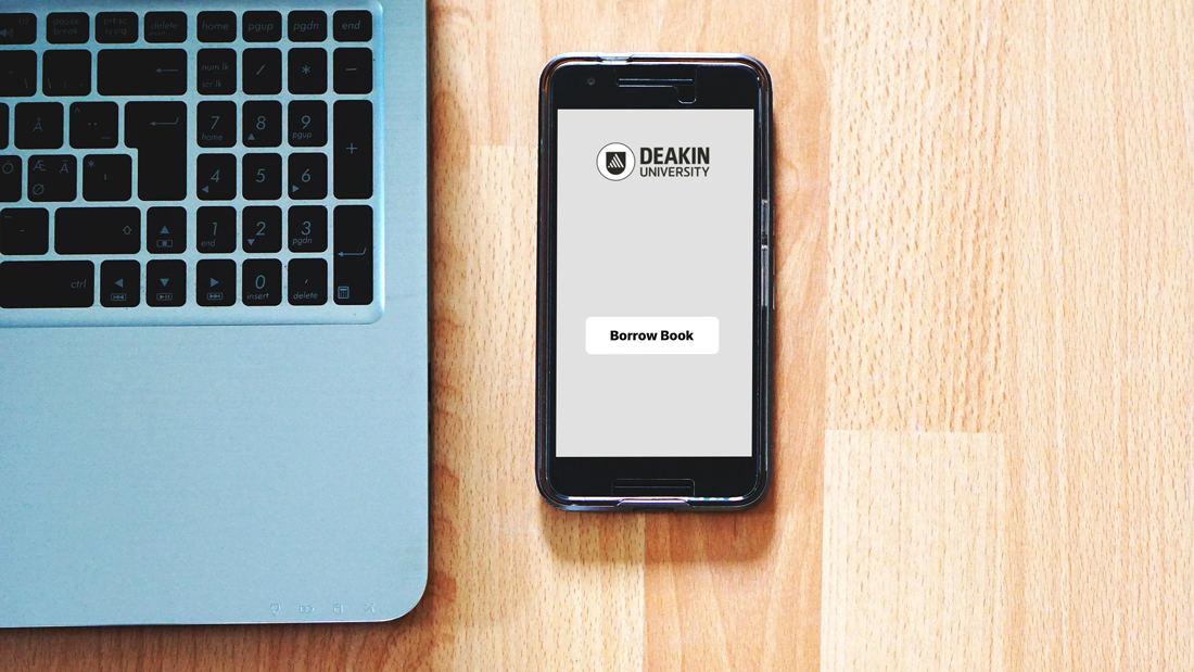 Mobile phone with Deakin Borrow app on a wood table