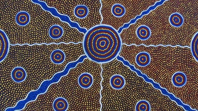 Indigenous australian artwork featuring many circles around a central large circle, with lines cutting across the space