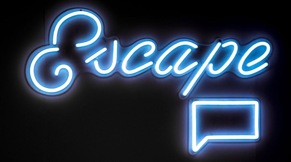 A neon sign against a black background. The sign says 'Escape'. Photo by Jason Leung on Unsplash