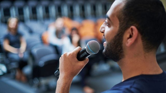 Close up of someone speaking into a microphone