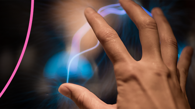 Close up of an outstretched hand with a visual effect in the background that looks similar to a plasma ball.