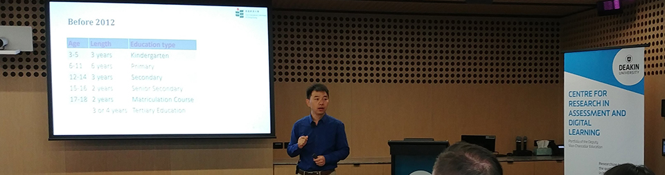 A/Prof. Yan Zi presenting in front of a slideshow screen