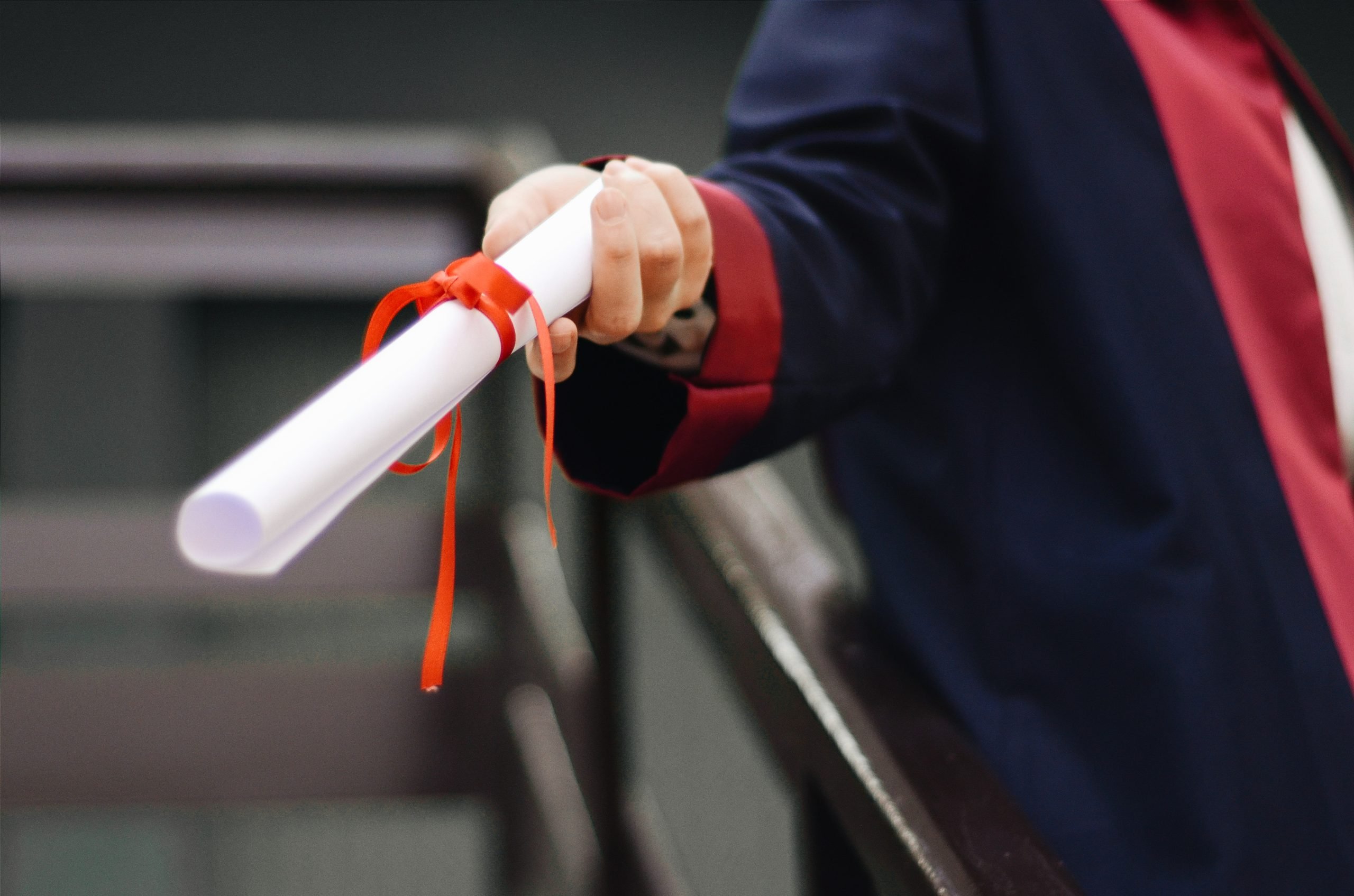 person holding white scroll for graduation