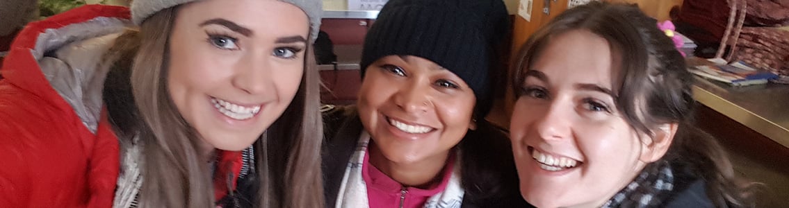 Two Deakin students on Study Abroad trip to Nepal with local woman