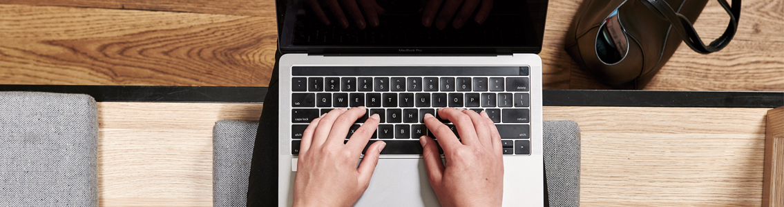 close-up of hands typing on a laptop
