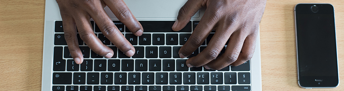 close up of man's hand typing on a laptop