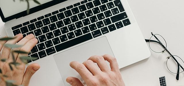 Close-up shot of hands on laptop keyboard