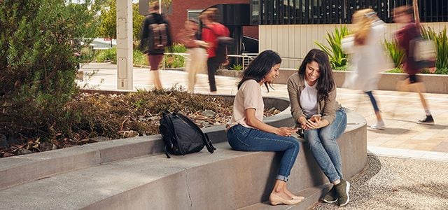 Two female students chatting on campus