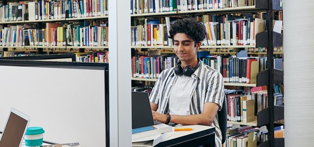 Student working on laptop in library