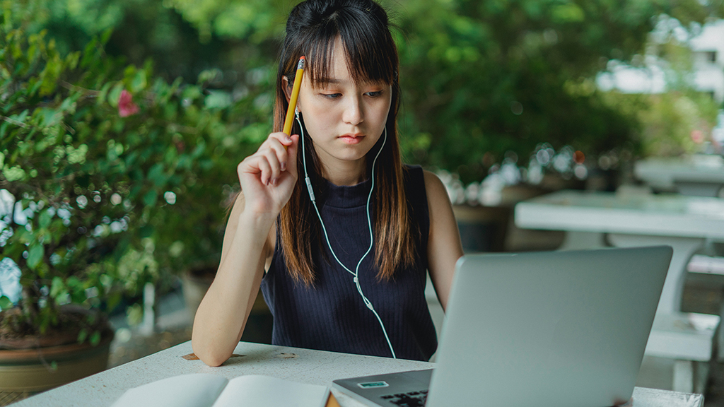 Female student with headphones on laptop