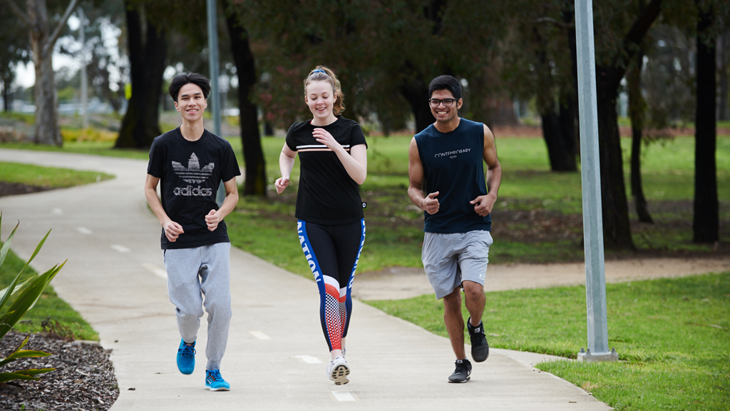 Three students jogging outside at Waurn Ponds Campus