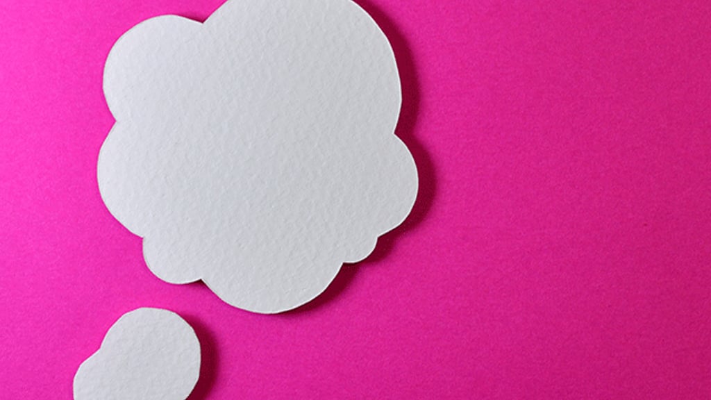 Paper cut-out of thought bubbles on bright pink background