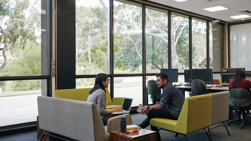 Two students chatting while seated in study area at Waurn Ponds library