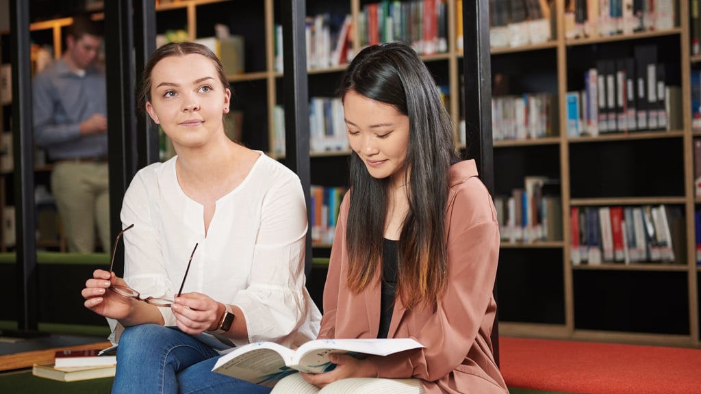 Two students sitting in library together
