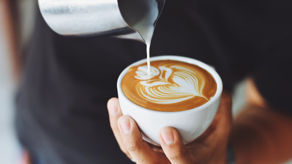 Barista pouring milk into an espresso cup
