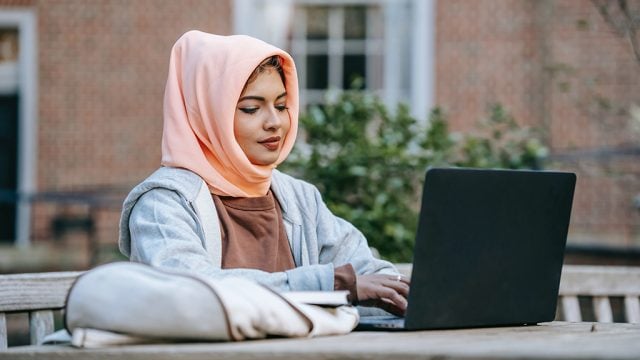 Woman in hajib looking at laptop