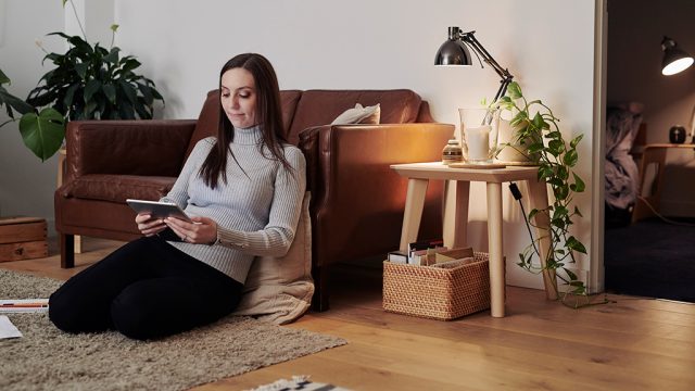Girl sitting on floor of apartment with tablet
