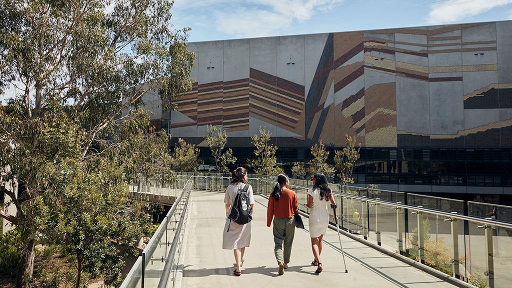 Three students walking across Burwood Campus