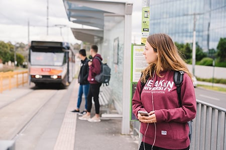 Student waits for tram outside Burwood Campus