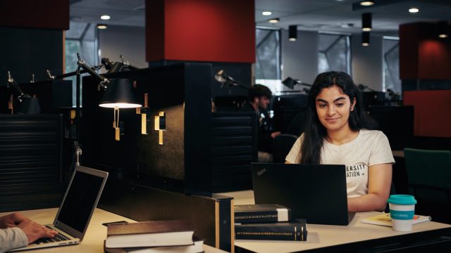 Student working on laptop in quiet study area of library