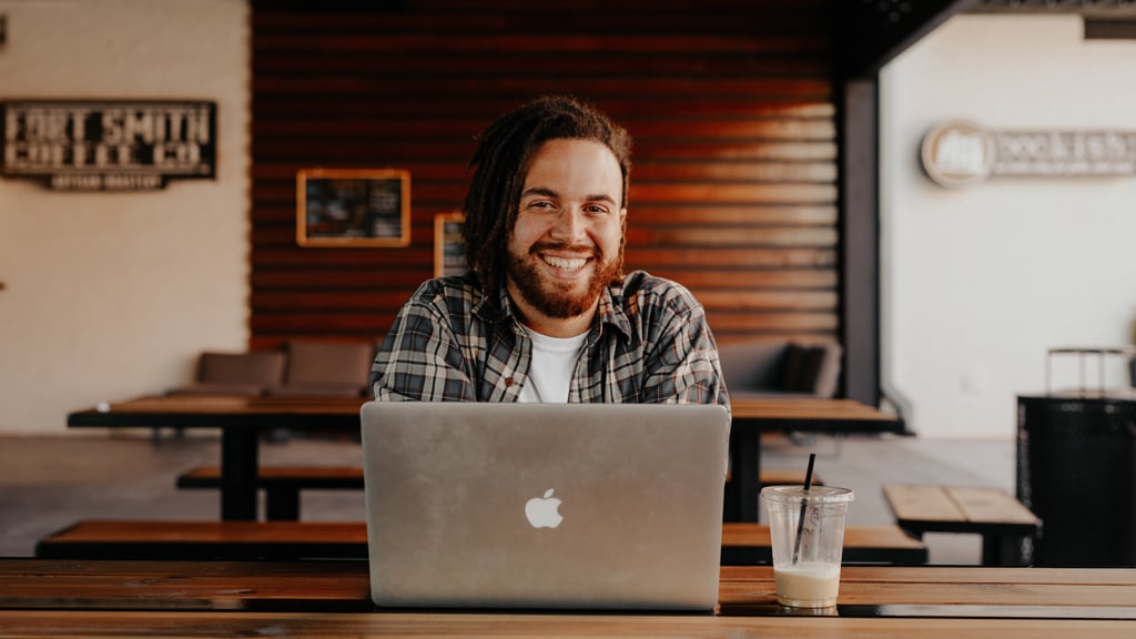 Man smiling as he sits at his laptop