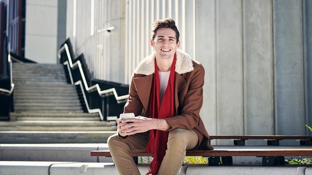 Smiling male student sitting outside Building LC