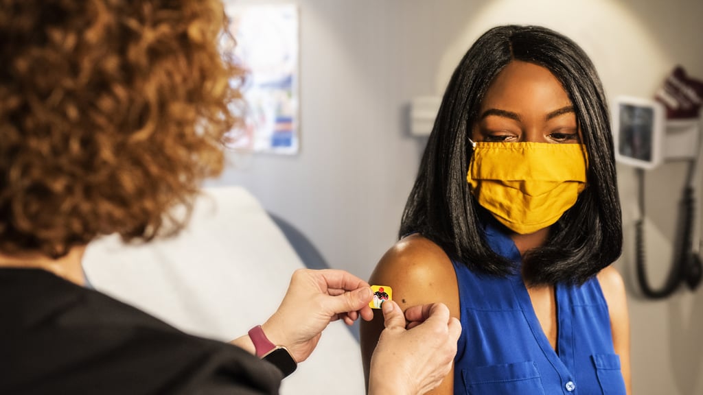 Young woman receiving sticking plaster after vaccination