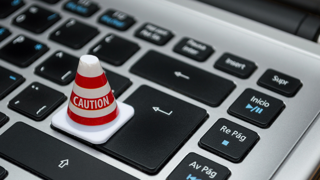 Miniature 'caution' sign placed on keyboard