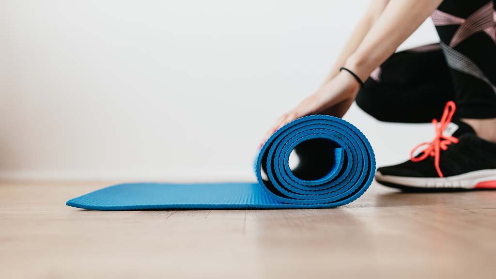 Woman unrolling exercise mat
