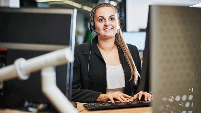 Smiling female student with headset and computer