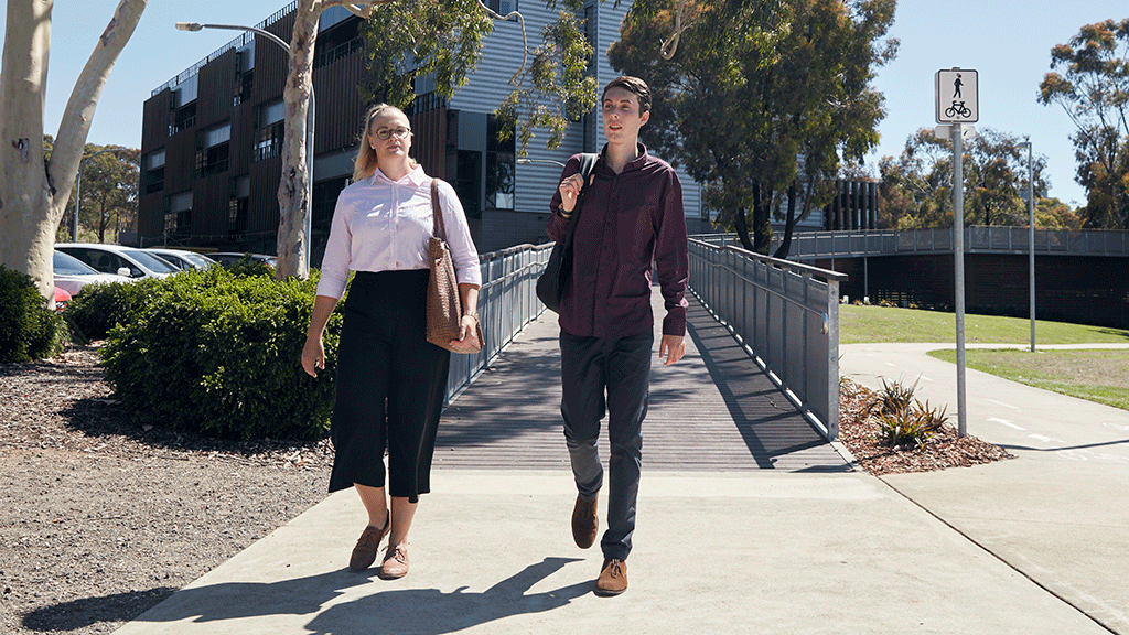 Male and female student walking together across Waurn Ponds Campus