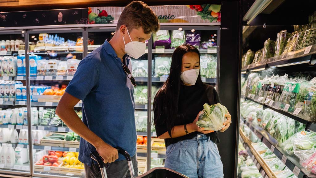 Two students looking at fresh produce in supermarket
