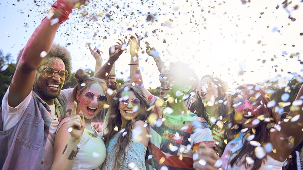 Group of young people at outdoor festival with confetti