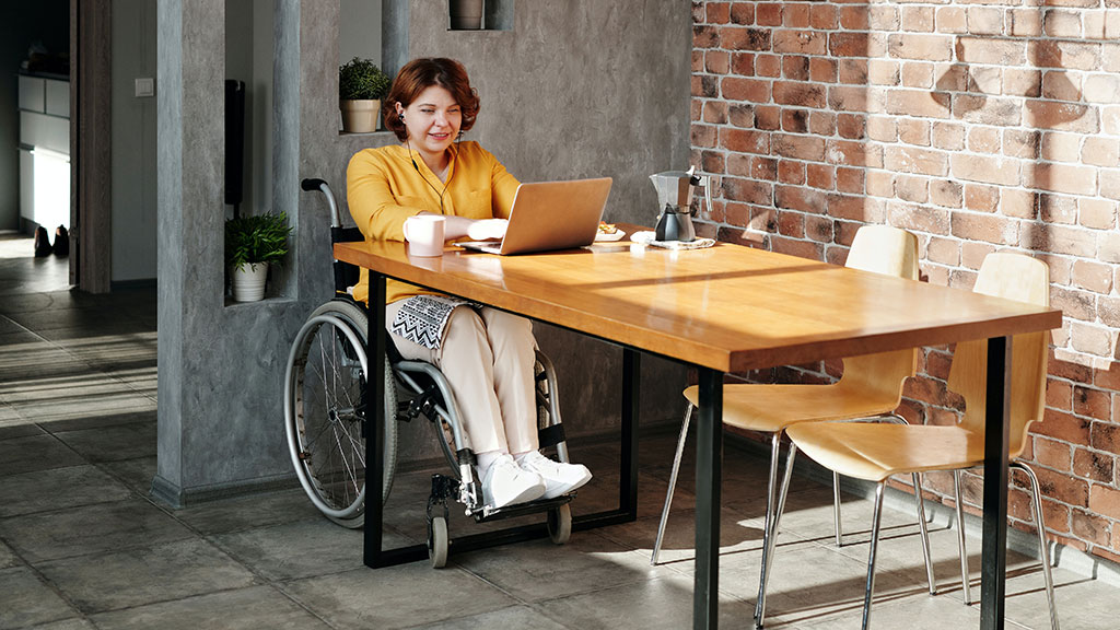 Woman in wheelchair looking at laptop