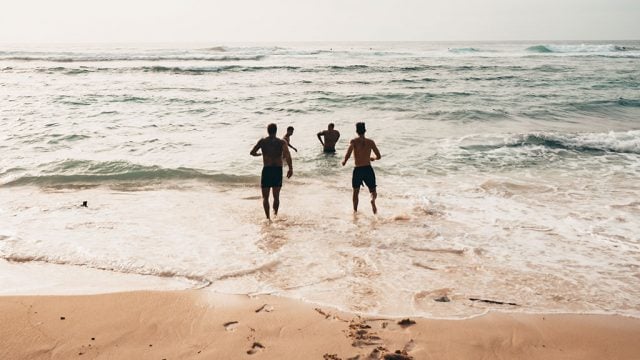 Young adults swimming at the beach