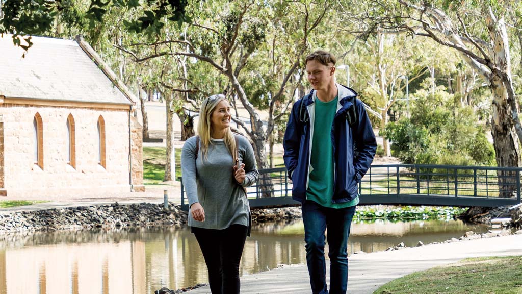 Two students walking by the lake at Waurn Ponds Campus