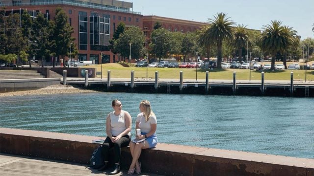 Two students chatting outside Waterfront Campus
