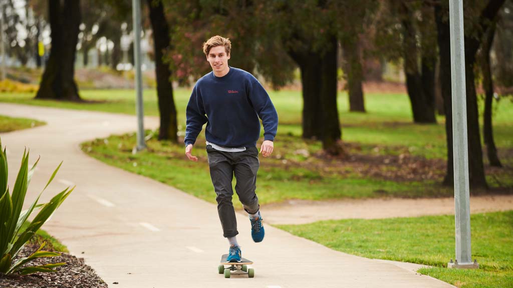 Male student skateboarding through Waurn Ponds Campus