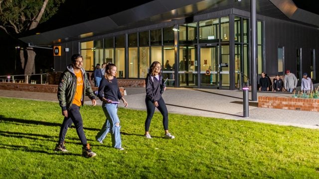 Students walking at night in front of Deakin residences