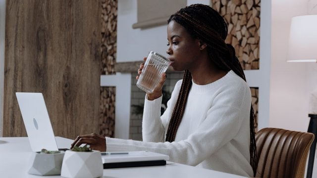 Female student drinking water while studying