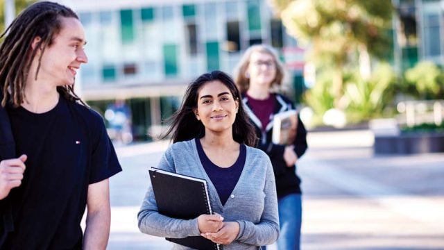 Student smiling as she walks through Burwood Campus with friends