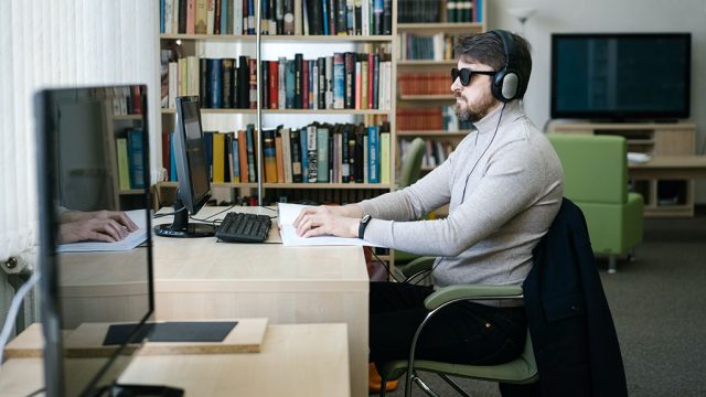 Male in library using assistive technology