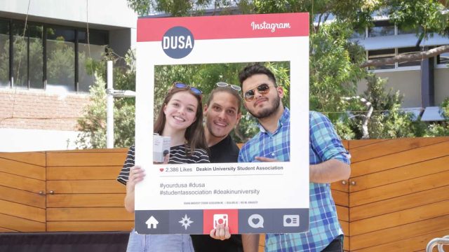 Students posing behind DUSA Instagram prop during an OFest event