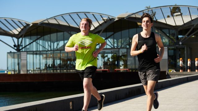 Two students running outside Waterfront Campus
