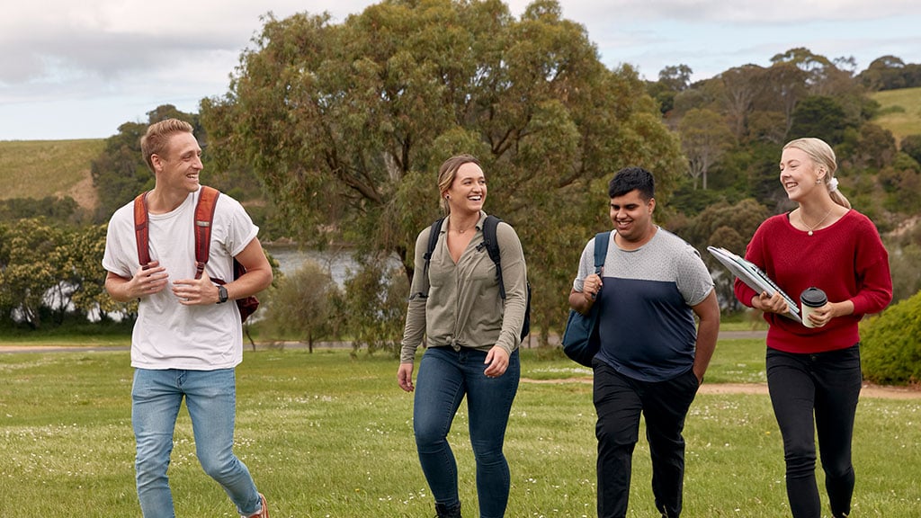 Group of four students walking at Warrnambool Campus