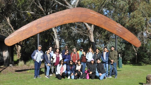 International students posing in front of a boomerang at Narana Cultural Centre