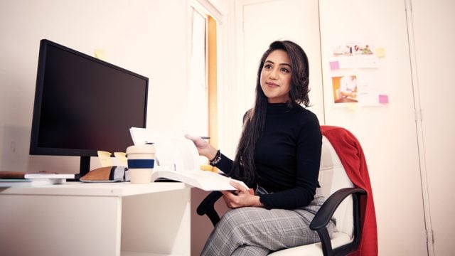 Student smiling as she studies in home office
