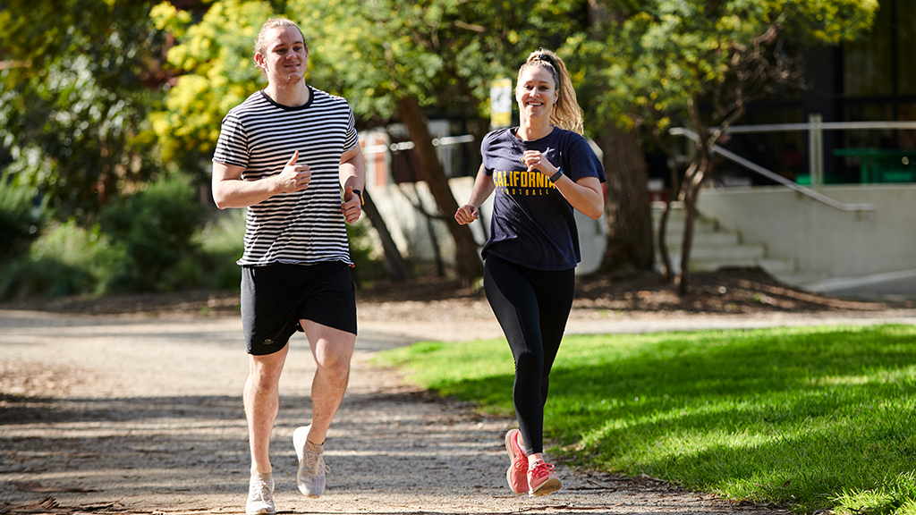 Two students running on campus.